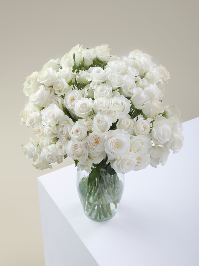 Bouquet of white spray roses arranged in a glass vase on a light background.
#color_white